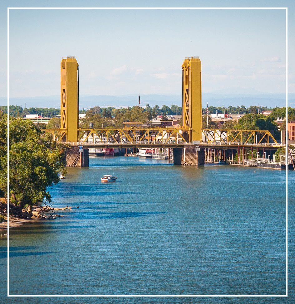 Golden bridge over calm blue river.