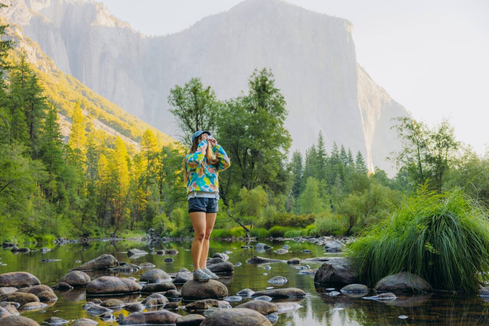 Person standing on rocks in scenic landscape.