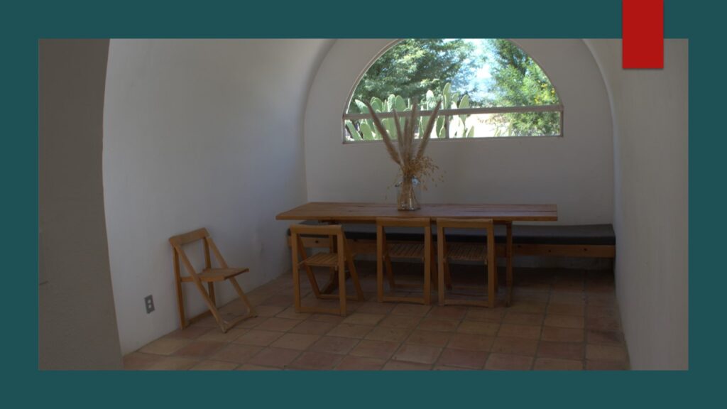 Desert landscape with mountains and sparse greenery under a cloudy sky.