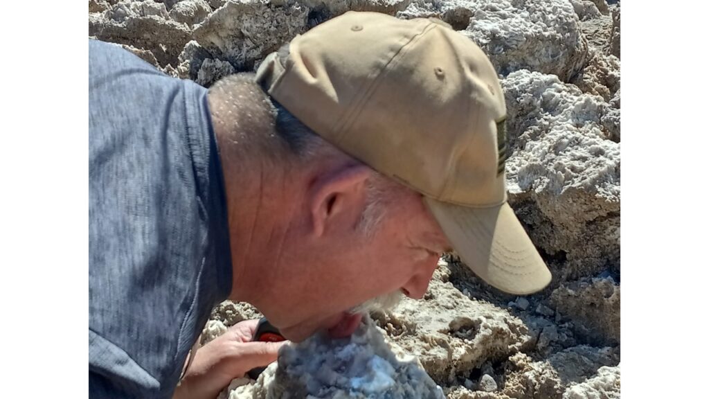 Man standing next to a small private airplane on a cloudy day.