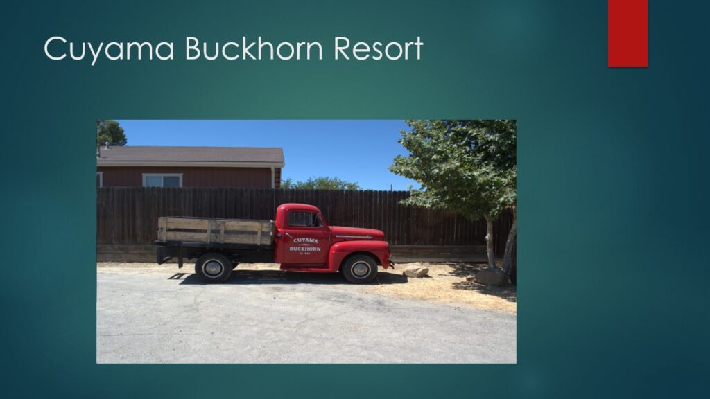 A vintage red truck parked outside a rustic building at Tula Buckhorn Resort.