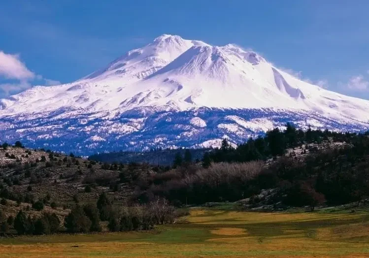 Snow-capped mountain under clear blue sky.
